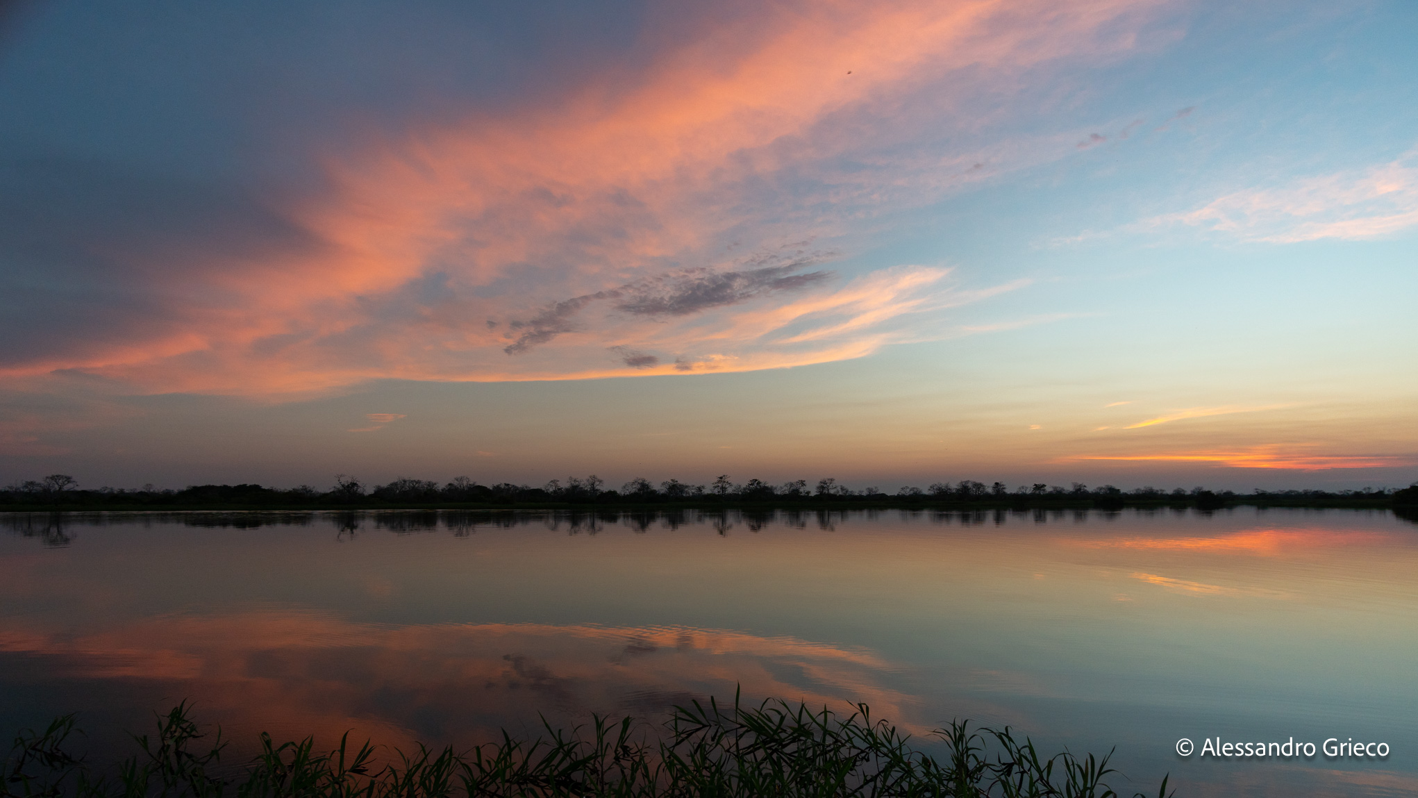 Sunset over the Mamirauá lake, the forest a thin line between two skies